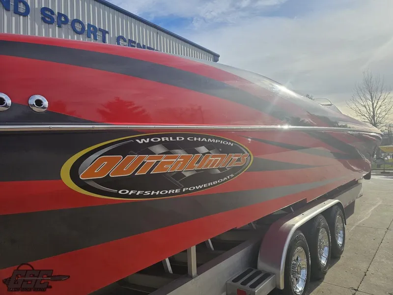 Slide: The Image of 2010 Outerlimits 52 SL powerboat with red and black design on a trailer. - 11