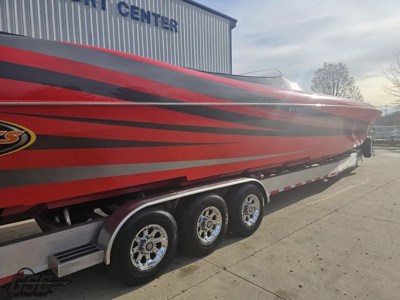 Slide: The Image of 2010 Outerlimits 52 SL powerboat with red and black stripes on a trailer. - 12