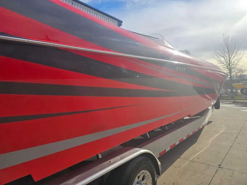 Slide: The Image of Red and black 2010 Outerlimits 52 SL boat on trailer under a sunny sky. - 15