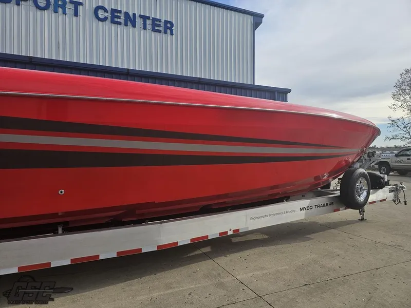 Slide: The Image of Red 2010 Outerlimits 52 SL boat on trailer outside a transport center. - 17