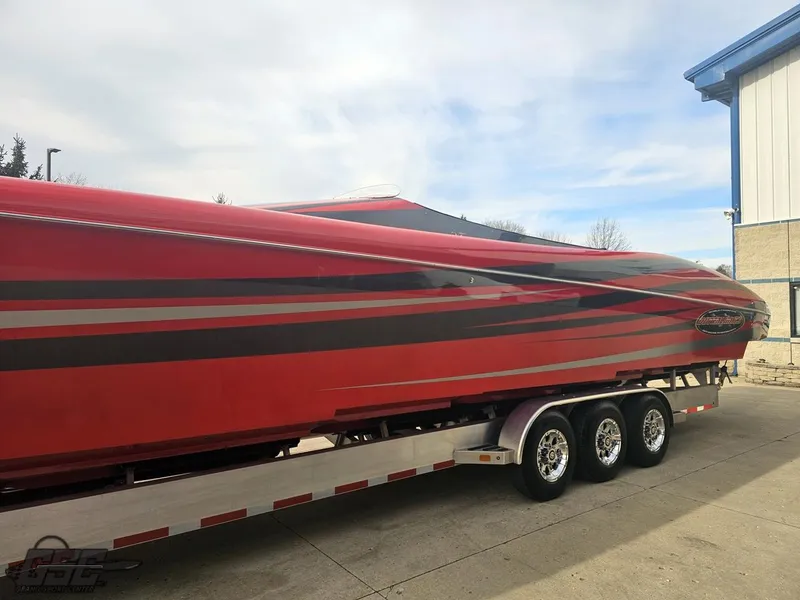Slide: The Image of Red 2010 Outerlimits 52 SL speedboat on a trailer, parked outdoors. - 26