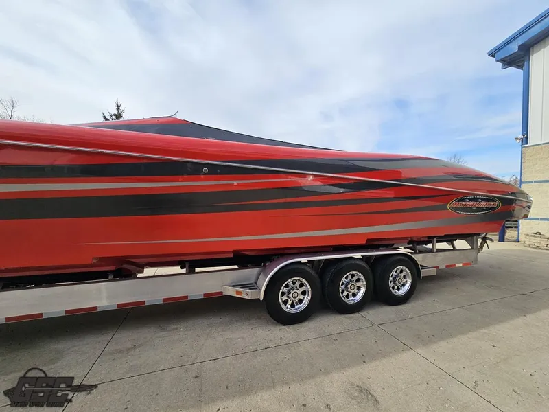Slide: The Image of 2010 Outerlimits 52 SL powerboat on trailer, red and black design, parked outdoors. - 31