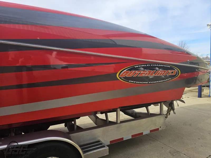 Slide: The Image of 2010 Outerlimits 52 SL powerboat with red and black stripes on a trailer. - 32