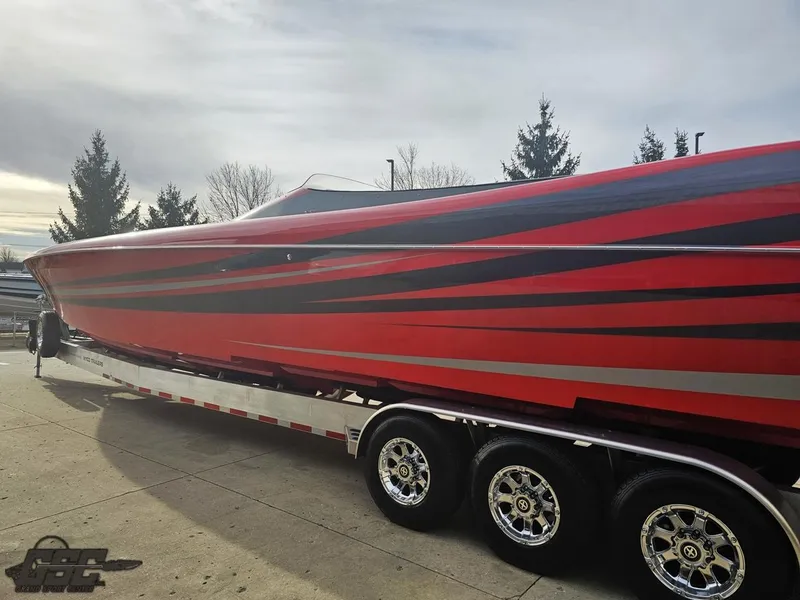 Slide: The Image of Red and black 2010 Outerlimits 52 SL speedboat on a trailer, parked outdoors. - 34