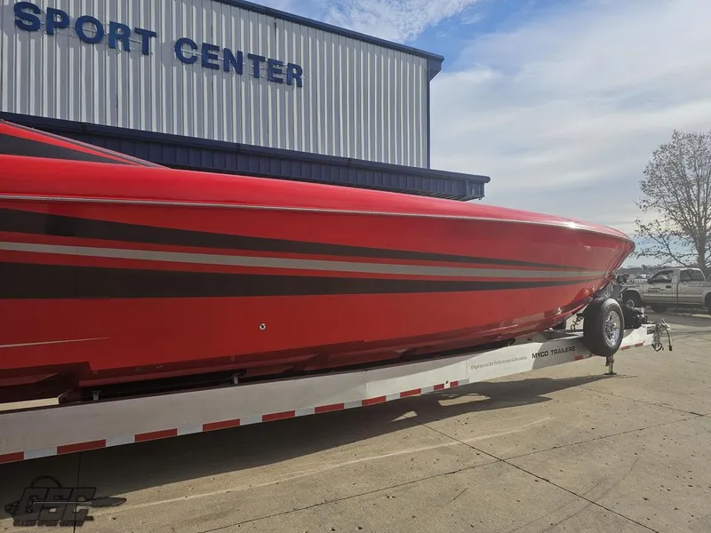 Slide: The Image of Red 2010 Outerlimits 52 SL boat on trailer outside sport center. - 4