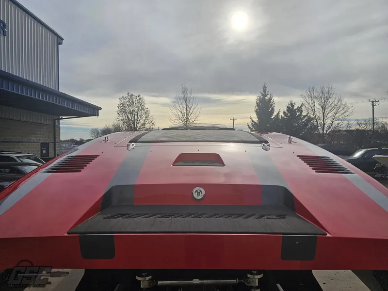 Slide: The Image of 2010 Outerlimits 52 SL boat, rear view, red with gray stripes, parked outdoors. - 40