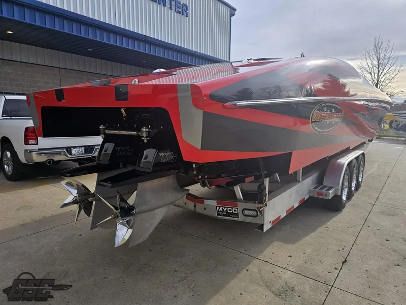 Slide: The Image of 2010 Outerlimits 52 SL powerboat on trailer, red and gray design, parked outdoors. - 43