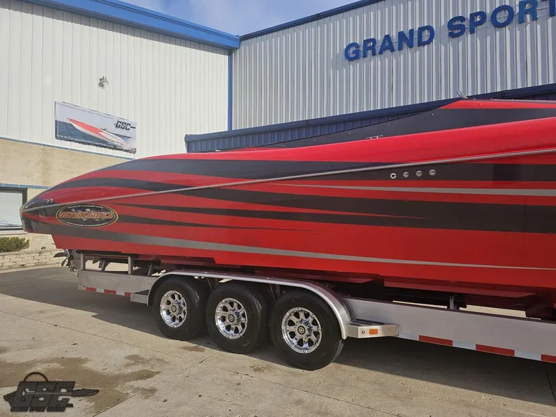 Slide: The Image of Red 2010 Outerlimits 52 SL boat on trailer outside Grand Sport Center. - 5