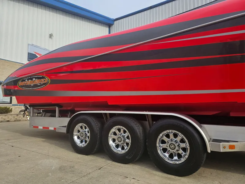 Slide: The Image of Red 2010 Outerlimits 52 SL boat on a trailer, showcasing sleek design and vibrant colors. - 7