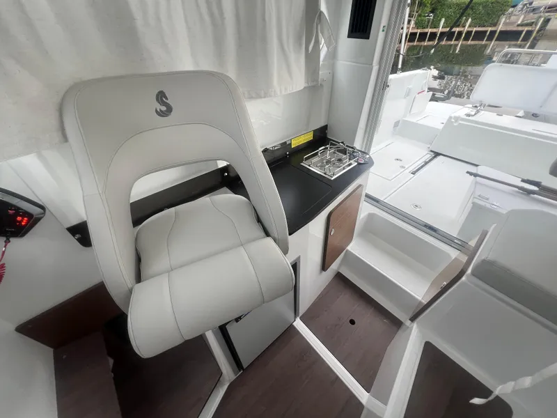Slide: The Image of Interior of 2025 Beneteau Antares 8 boat with seating and compact kitchen area. - 10