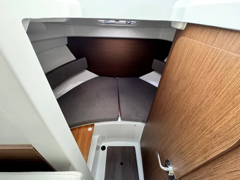 Slide: The Image of 2025 Beneteau Antares 8 cabin interior with cozy bedding and wooden accents. - 15