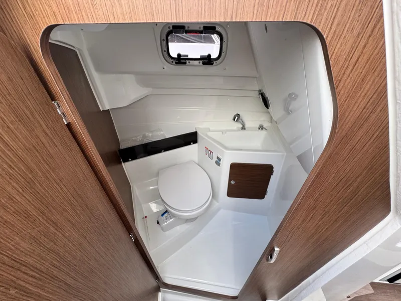 Slide: The Image of 2025 Beneteau Antares 8 boat bathroom with modern fixtures and wood accents. - 17