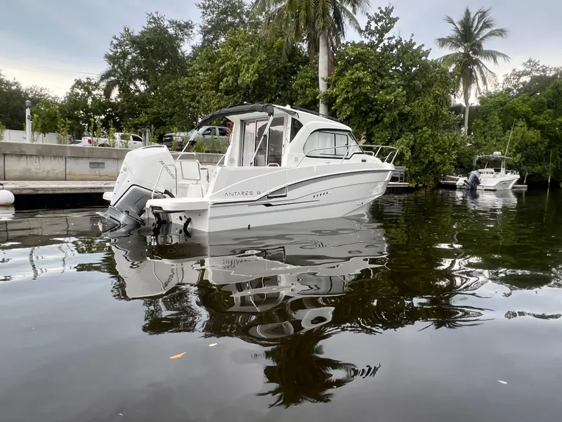 Slide: The Image of 2025 Beneteau Antares 8 boat docked on calm water, surrounded by lush greenery. - 3