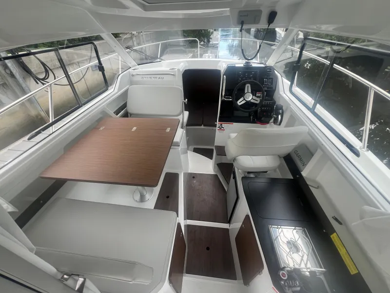 Slide: The Image of 2025 Beneteau Antares 8 interior with helm, seating, and table. - 7