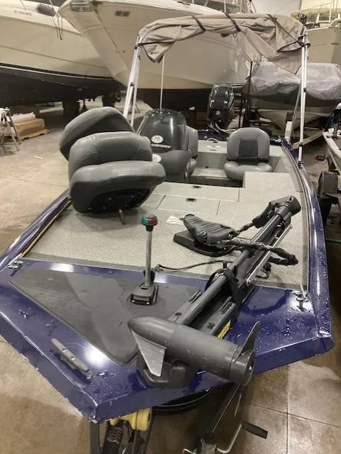 Slide: The Image of 2019 Tracker Pro 170 boat with seating and fishing equipment in a showroom. - 2