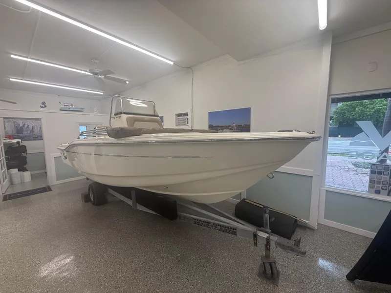 Slide: The Image of 2024 Scout 175 Sportfish boat displayed indoors on a trailer. - 1