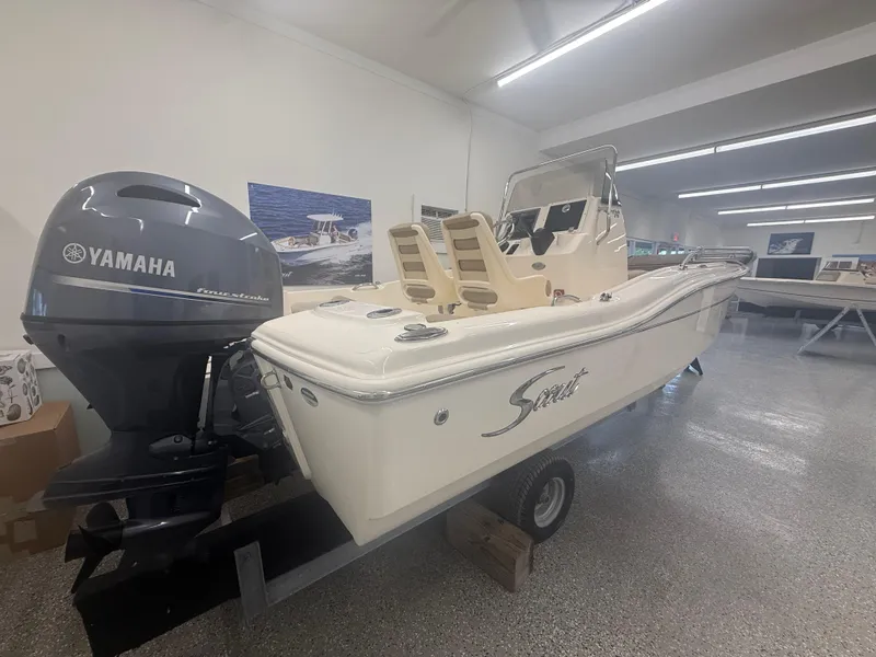 Slide: The Image of 2024 Scout 175 Sportfish boat with Yamaha engine displayed indoors. - 2