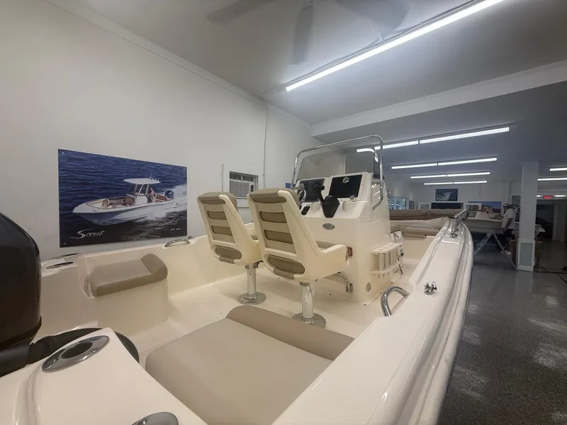 Slide: The Image of 2024 Scout 175 Sportfish boat interior in showroom, featuring seating and control console. - 3