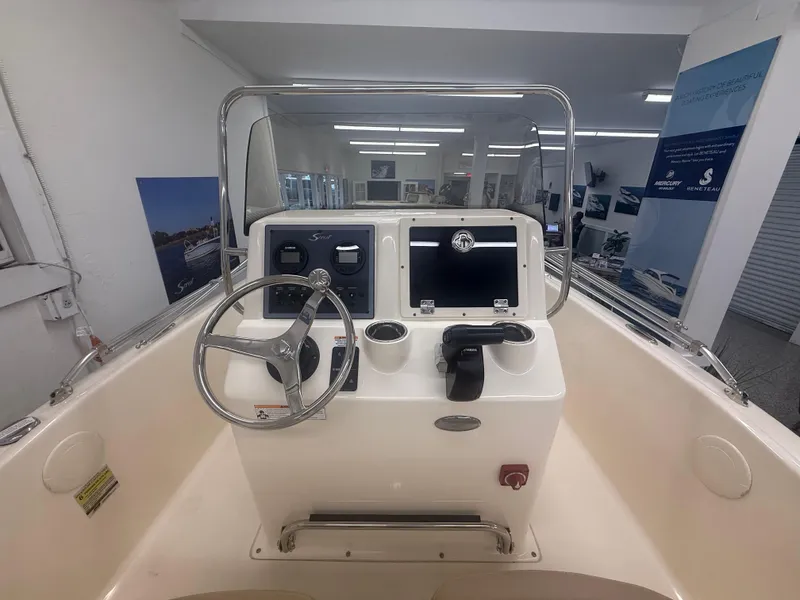 Slide: The Image of 2024 Scout 175 Sportfish boat console with steering wheel and controls in showroom. - 6