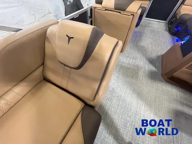 Slide: The Image of 2025 Tahoe LTZ 2385 Cruise Tritoon interior with tan leather seating, Boat World logo. - 19