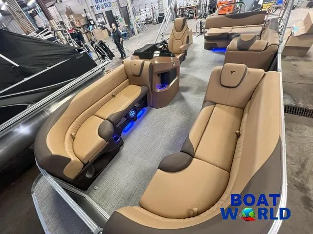 Slide: The Image of 2025 Tahoe LTZ 2385 Cruise Tritoon with luxurious seating and ambient lighting in showroom. - 23