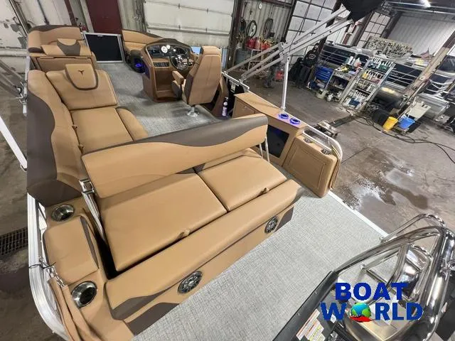 Slide: The Image of 2025 Tahoe LTZ 2385 Cruise Tritoon with tan interior, rear bench, and modern dashboard. - 26