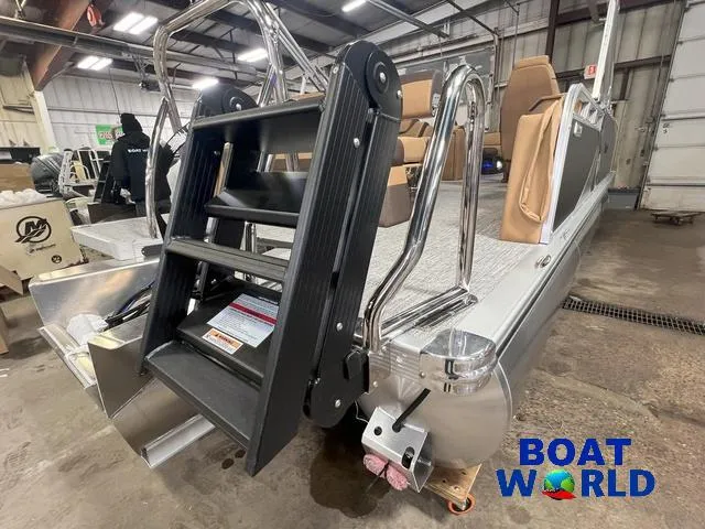 Slide: The Image of 2025 Tahoe LTZ 2385 Cruise Rear Bench Tritoon in showroom, featuring sturdy boarding ladder. - 28