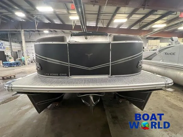 Slide: The Image of 2025 Tahoe LTZ 2385 CRB Tritoon in showroom, rear view with Boat World logo. - 33