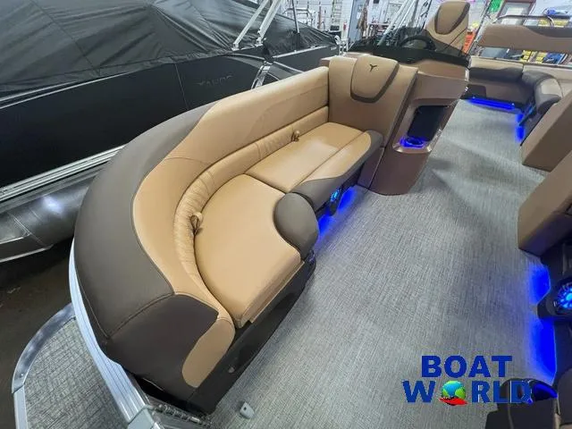 Slide: The Image of 2025 Tahoe LTZ 2385 Cruise Tritoon interior with tan and brown seating, blue LED lighting. - 7