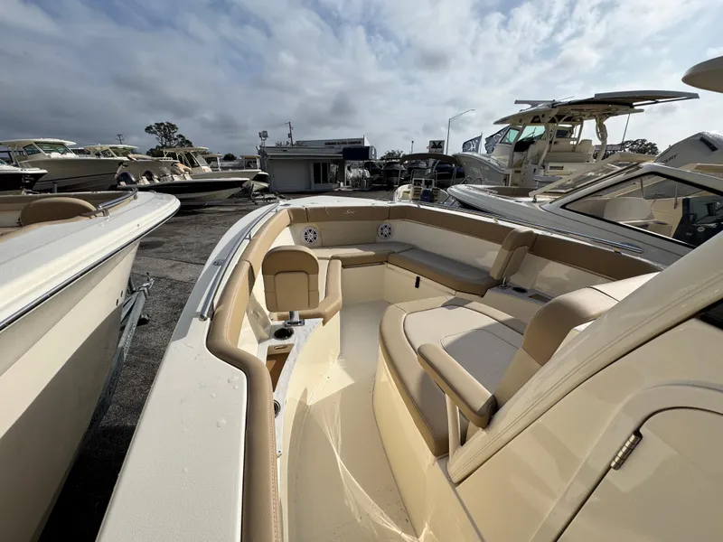 Slide: The Image of 2025 Scout 240 XSF boat with beige interior, docked among other boats. - 12
