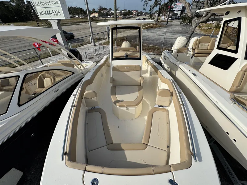 Slide: The Image of 2025 Scout 240 XSF boat with beige seating, displayed outdoors. - 13