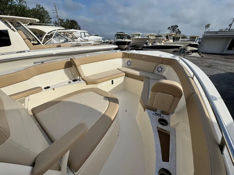 Slide: The Image of 2025 Scout 240 XSF boat interior with beige seating and cup holders. - 16