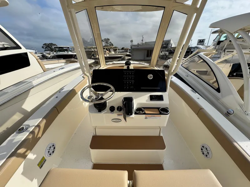 Slide: The Image of 2025 Scout 240 XSF boat interior with steering console and seating. - 9