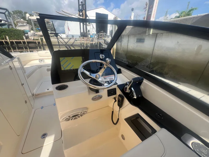 Slide: The Image of 2025 Scout 277 Dorado boat cockpit with steering wheel and navigation display. - 14