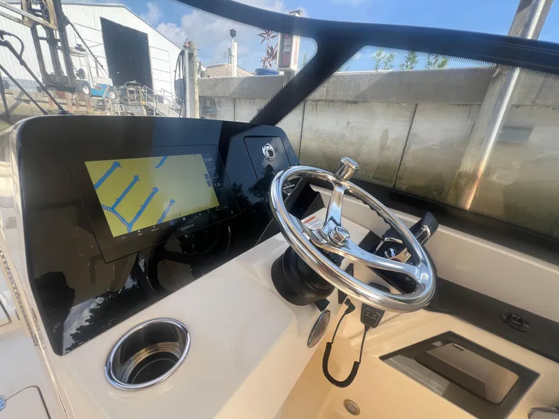 Slide: The Image of 2025 Scout 277 Dorado boat dashboard with steering wheel and navigation display. - 15