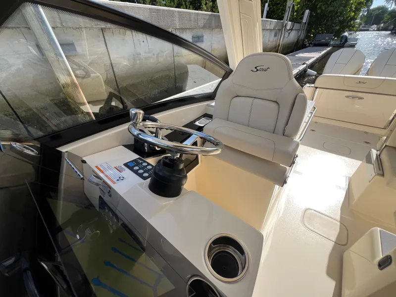 Slide: The Image of 2025 Scout 277 Dorado boat cockpit with steering wheel and comfortable seating. - 16