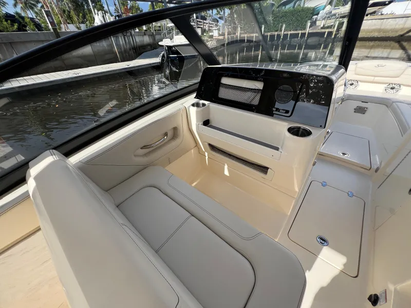 Slide: The Image of 2025 Scout 277 Dorado boat interior with seating and dashboard, docked by the water. - 18