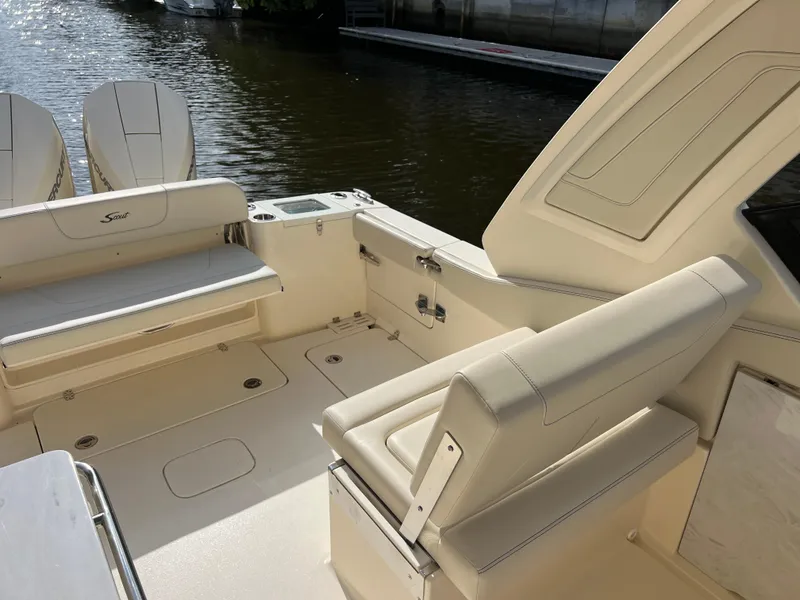 Slide: The Image of 2025 Scout 277 Dorado boat interior with beige seating and dual outboard motors. - 22
