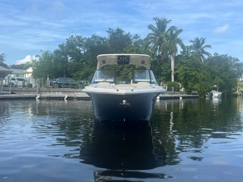 Slide: The Image of 2025 Scout 277 Dorado boat docked on calm water, surrounded by lush greenery. - 4