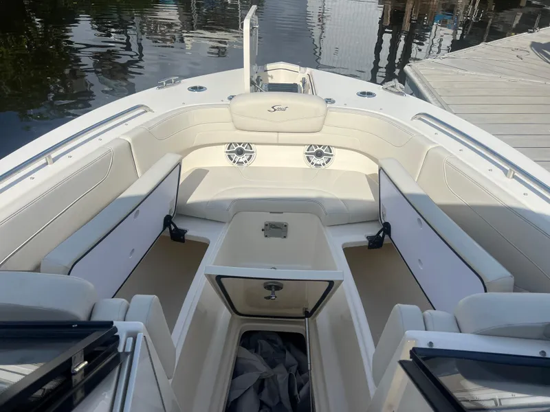 Slide: The Image of 2025 Scout 277 Dorado boat interior with spacious seating and storage, docked by the water. - 9