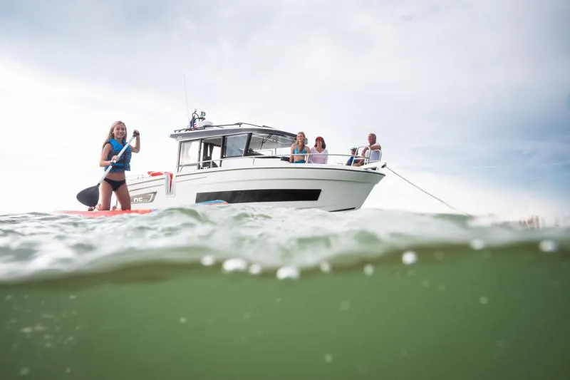 Slide: The Image of 2024 Jeanneau NC Sport 895 with people enjoying water activities nearby. - 11