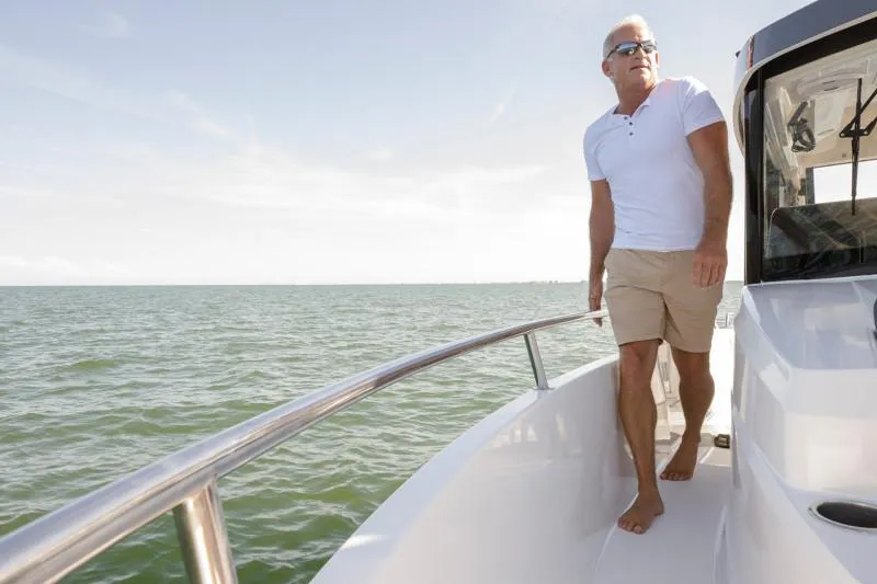 Slide: The Image of Man enjoying a sunny day on a 2024 Jeanneau NC Sport 895 boat. - 15