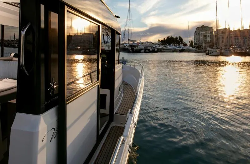 Slide: The Image of 2024 Jeanneau NC Sport 895 boat docked at sunset in a marina. - 16