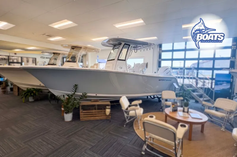 The Image of 2027 Sportsman Open 212 Center Console boat displayed in showroom with seating area. - 0