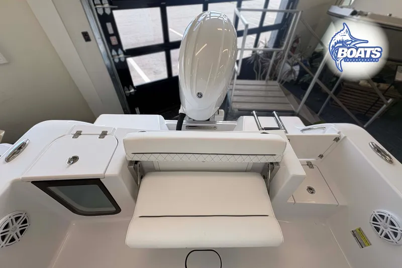 Slide: The Image of 2027 Sportsman Open 212 Center Console boat interior with seating and motor, displayed indoors. - 9