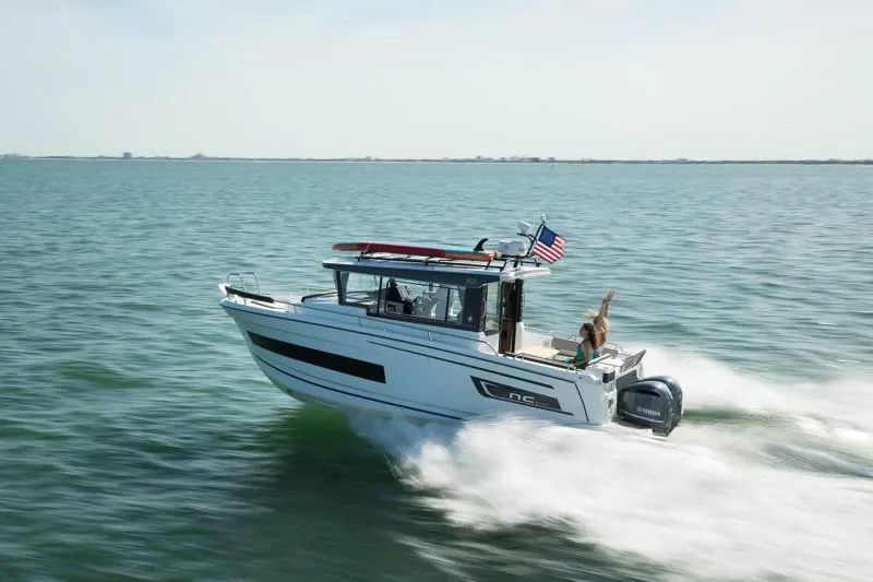 Slide: The Image of 2024 Jeanneau NC Sport 895 cruising on open water with American flag. - 7