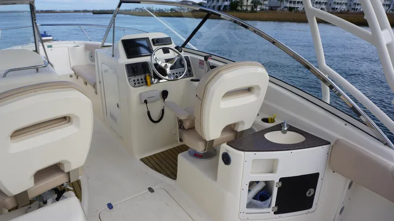 Slide: The Image of 2017 Scout 245 Dorado boat interior with steering wheel and seating. - 6