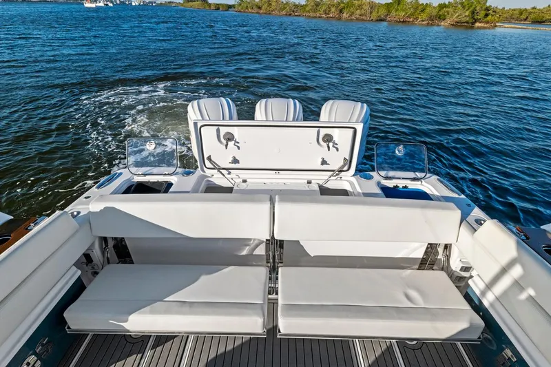 Slide: The Image of 2025 Everglades 375 Center Console boat interior with seating, on a scenic water backdrop. - 20