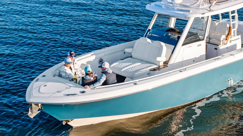 Slide: The Image of 2025 Everglades 375 Center Console boat cruising with passengers on blue water. - 9