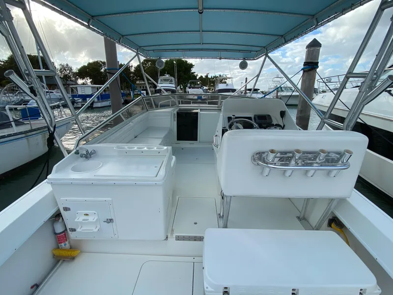 Slide: The Image of 1998 Contender 35 Express boat interior with seating and fishing rod holders. - 11